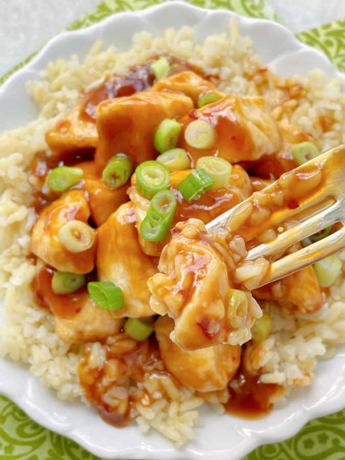 taking a bite of air fryer orange chicken