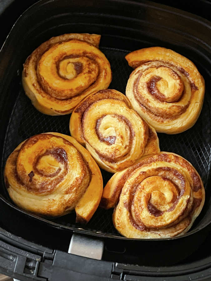 fully cooked cinnamon rolls in the air fryer basket