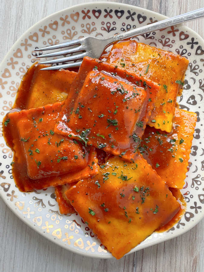 pumpkin ravioli on a plate with browned butter sauce
