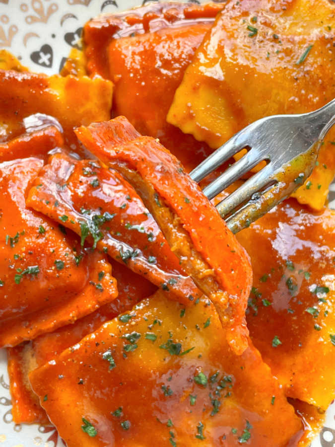 taking a bite of pumpkin ravioli with Thai browned butter sauce