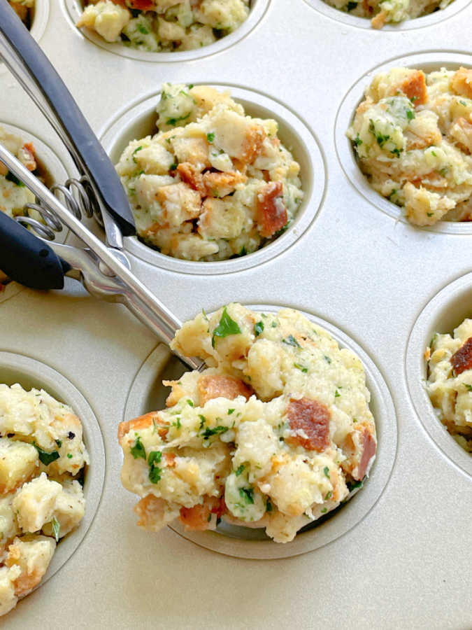 scooping stuffing into a muffin tin