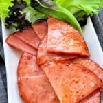 brown sugar glazed air fried ham on a platter with lettuce