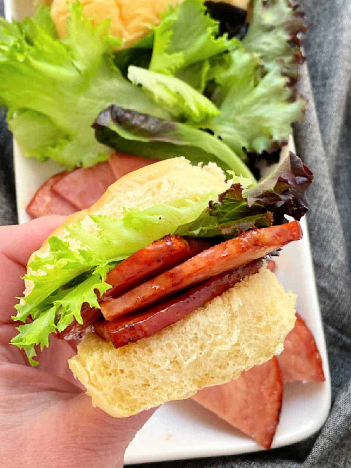 holding a slider sandwich made with air fryer ham