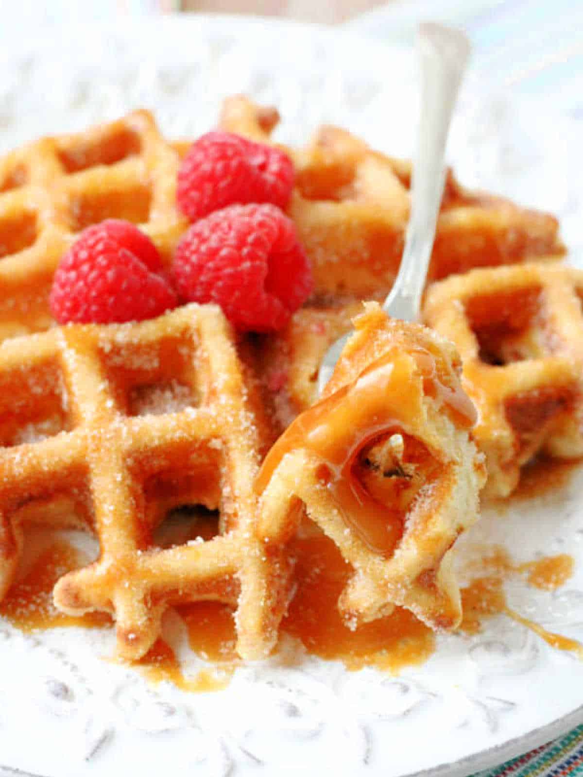 a forkful of churro waffle drizzled with caramel sauce