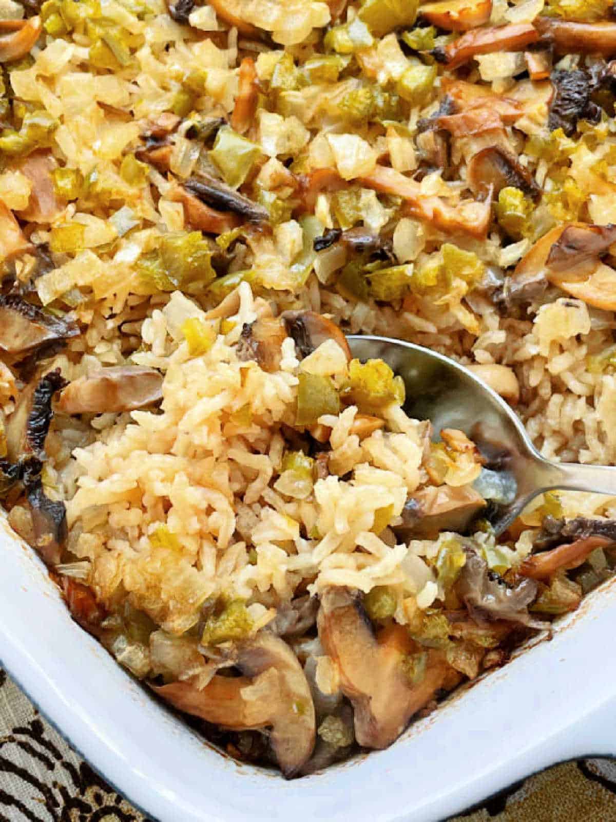 serving a spoonful of mushroom rice pilaf from the casserole dish