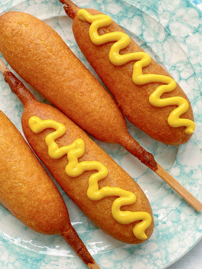 air fryer corn dogs topped with yellow mustard