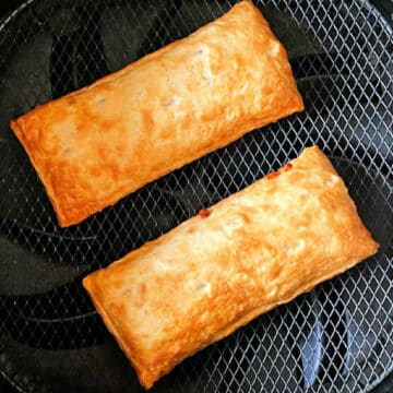 two cooked hot pockets in the basket of an air fryer