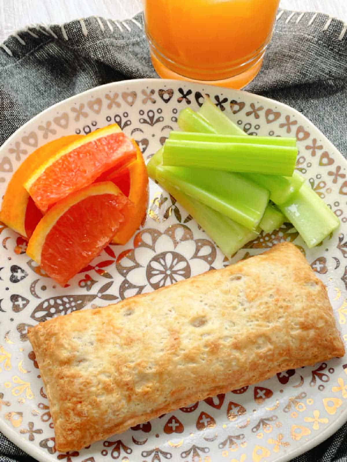 an air fried hot pocket plated with celery and oranges