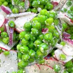 a serving spoon full of English pea salad