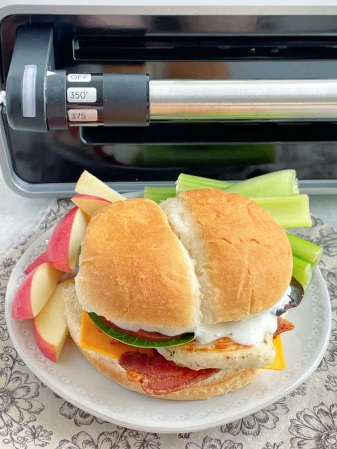 grilled chicken sandwich plated in front of the George Foreman Grill