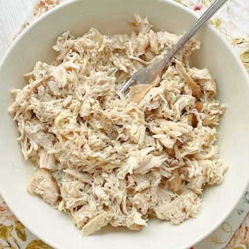 a bowl full of cooked, shredded chicken breast, cooked in the Crock-Pot