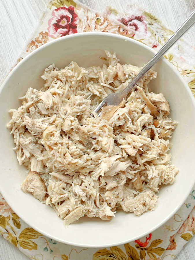 a bowl full of shredded chicken that has been cooked from frozen in the Crock-Pot