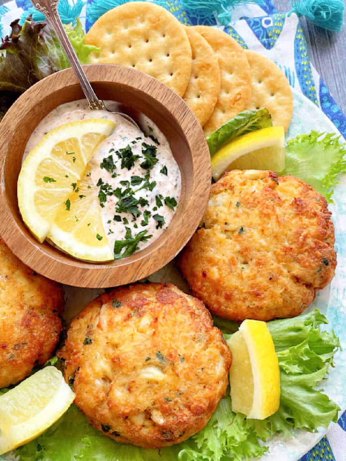 air fryer crab cakes plated with lemon wedges and a creamy dipping sauce