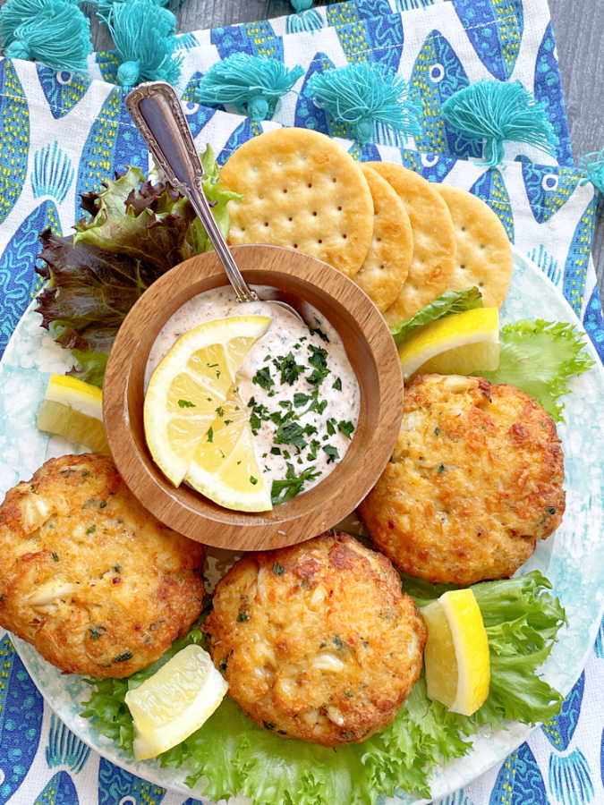 air fryer crab cakes plated with fresh lemons and crackers