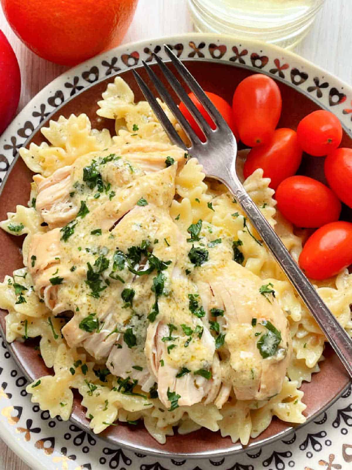 slow cooker ranch chicken plated with pasta and grape tomatoes