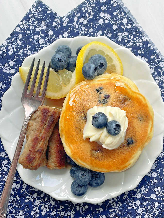 lemon blueberry pancakes plated with sausage