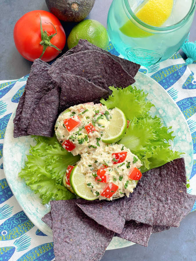 Mexican tuna salad served in avocado halves with tortilla chips for dipping