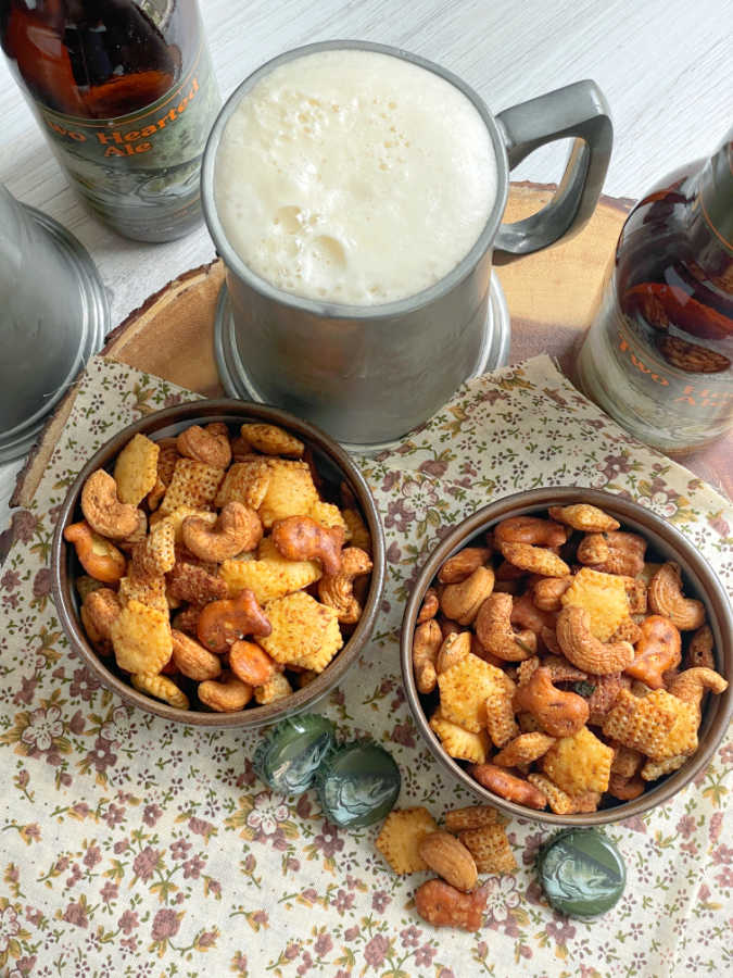 air fryer chex mix in small bowls pictured with steins of beer