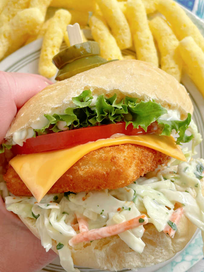 taking a bite of an air fryer frozen fish sandwich