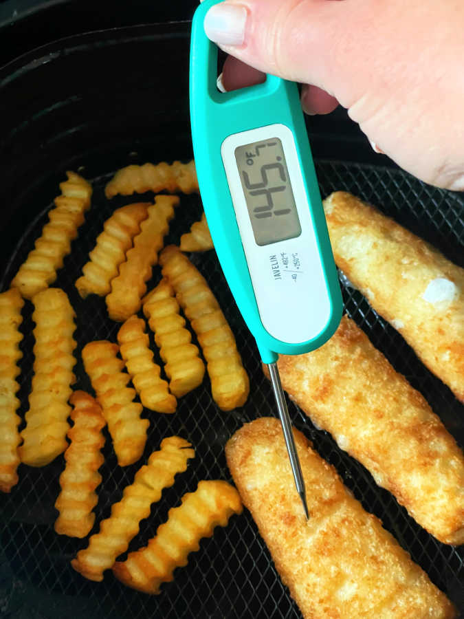 frozen fish fillets in the basket of an air fryer - showing being cooked to 145 degrees