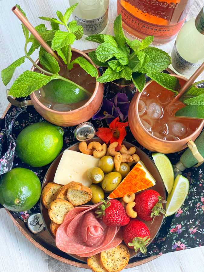 overhead view of bourbon mule pictured with a colorful charcuterie platter
