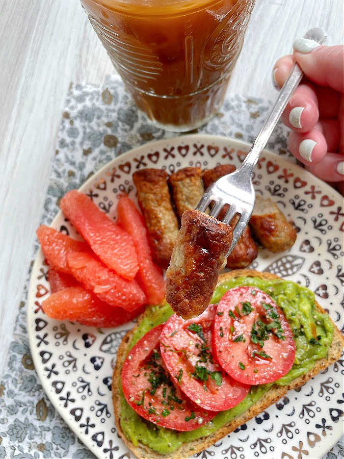 taking a bite of air fryer breakfast sausage