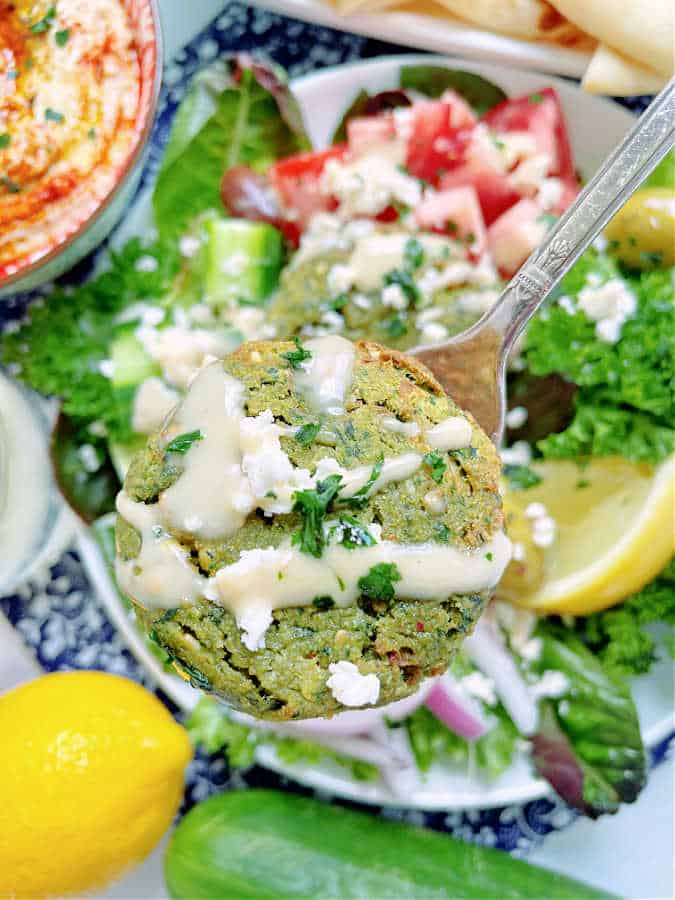 showing a close up of an air fryer falafel patty, drizzled in tahini sauce