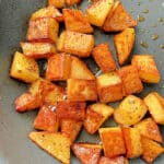 crispy breakfast potatoes cooking in a nonstick skillet