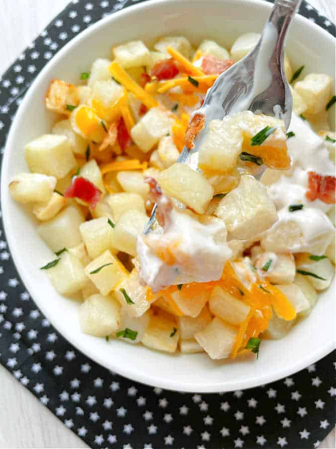 taking a bite of loaded hashbrown potatoes that were cooked in the air fryer