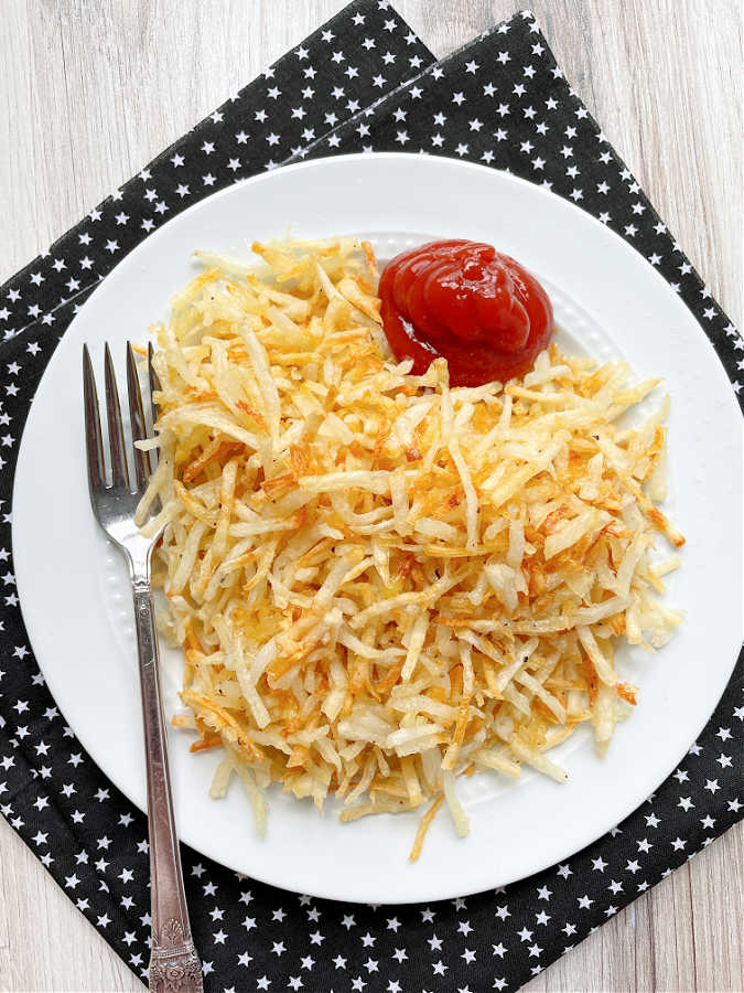 air fryer shredded hashbrowns plated with ketchup