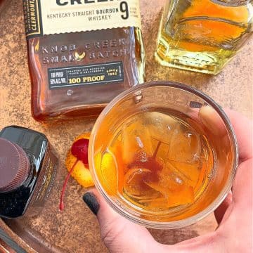 holding a perfect old fashioned cocktail