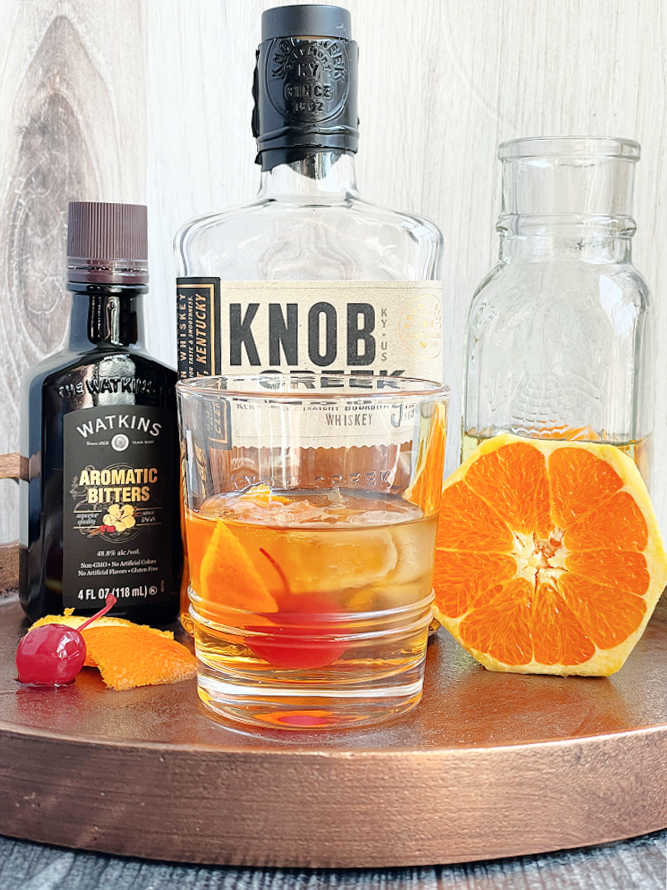 a perfectly mixed old fashioned cocktail, with all the ingredients shown in the background
