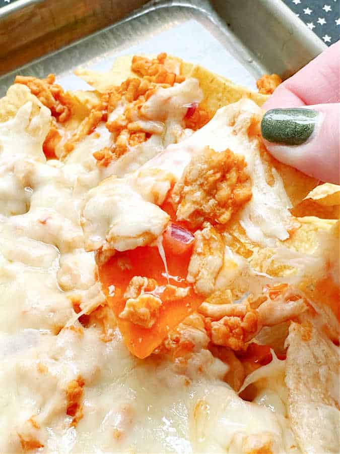 close up of melted cheese on top of the buffalo chicken nachos