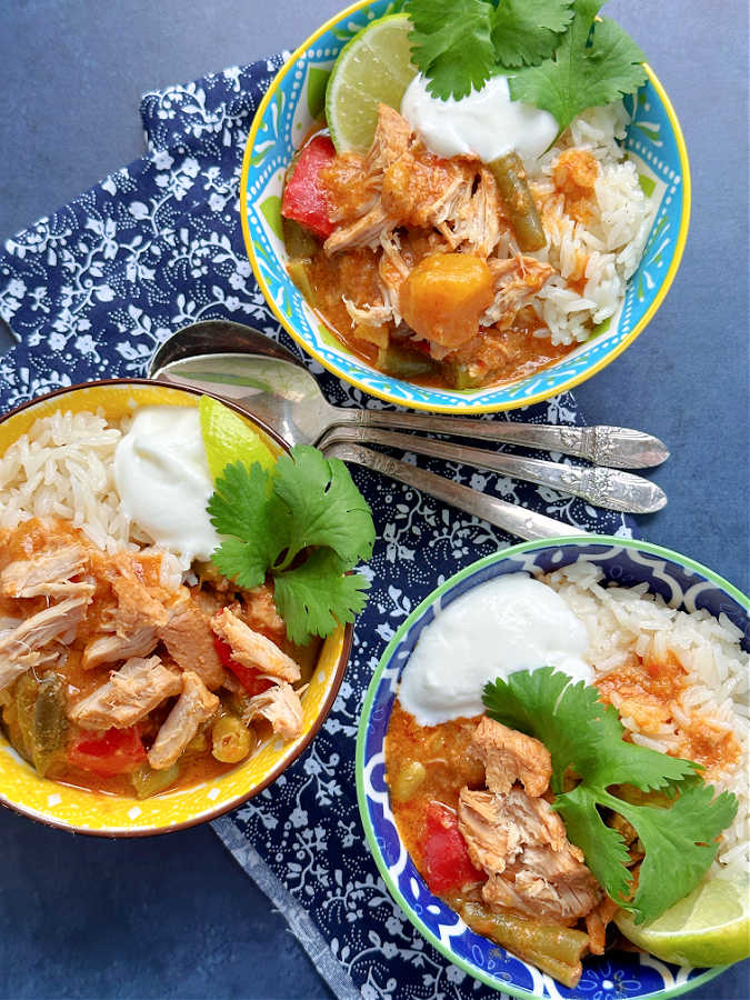 three pretty bowls of pork curry over rice