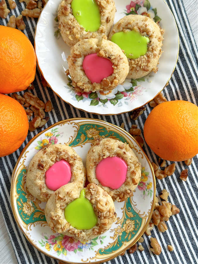 thumbprint cookies with icing on vintage plates iced with pink and green