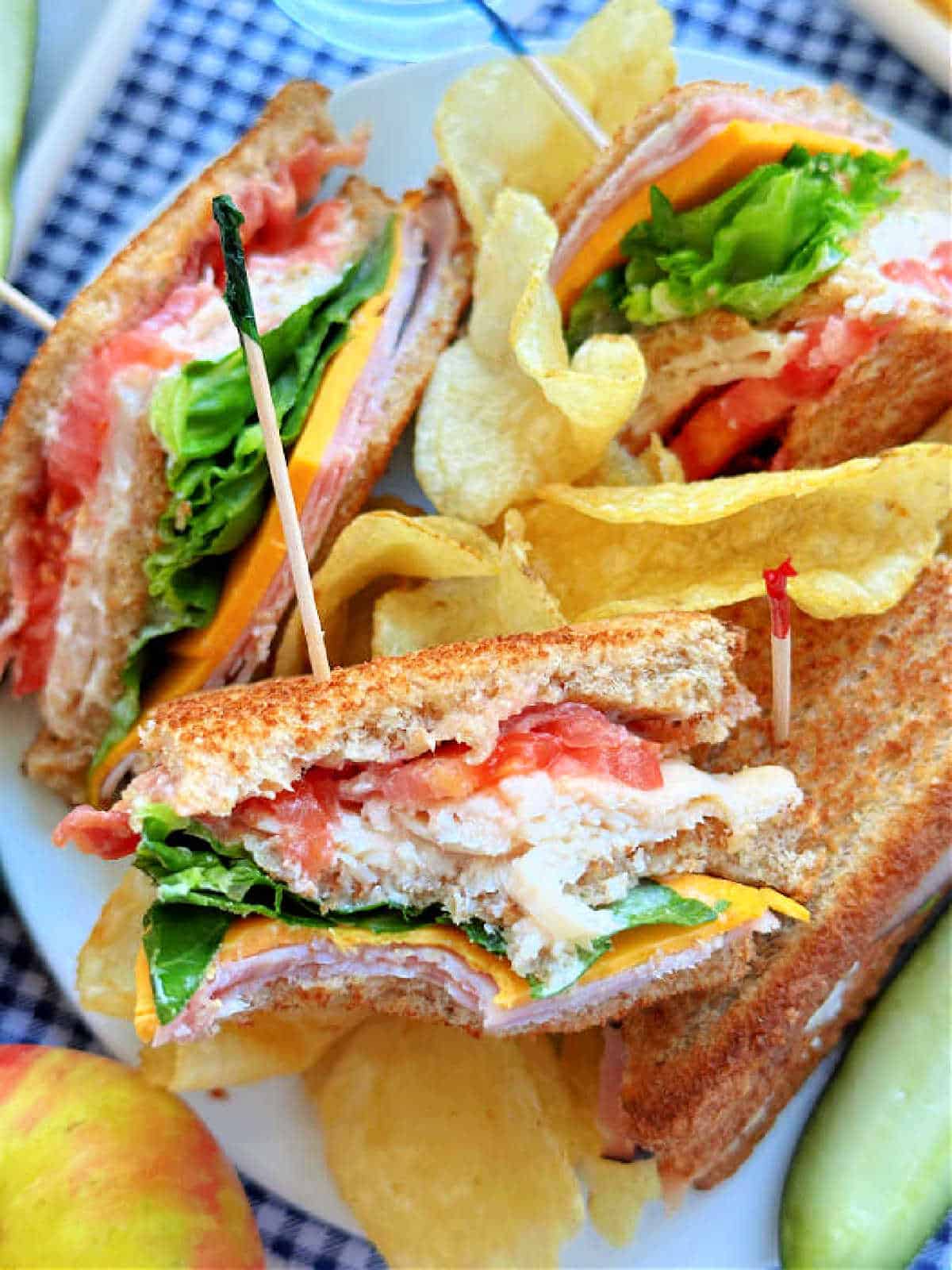 plated club sandwich and one triangle has a bite taken out of it