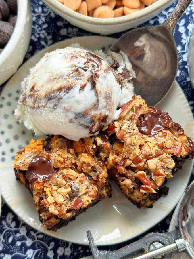 condensed milk brownies plated with a scoop of fudge ripple ice cream