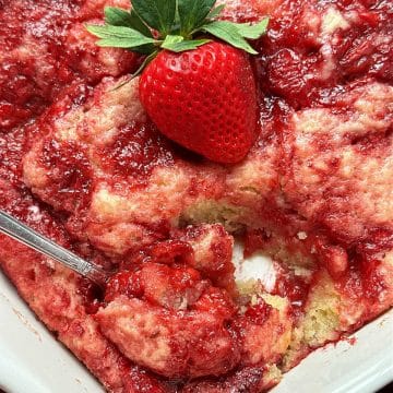 spooning a serving of strawberry spoon cake from the pan