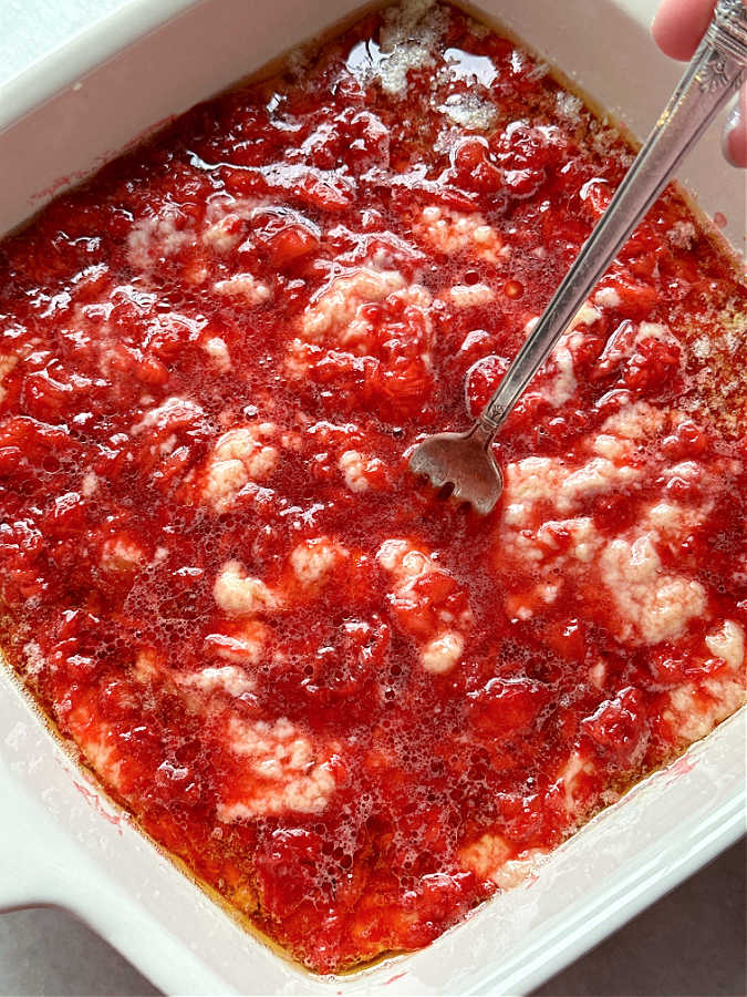 mixing the strawberry and cake layers together for strawberry spoon cake