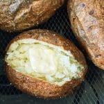 three russet potatoes in the air fryer basket