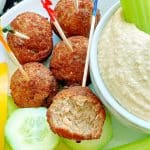 a snack of air fryer frozen meatballs plated with fresh veggies and hummus