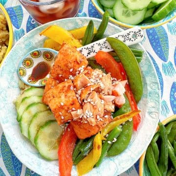 air fryer salmon bites in a bowl with rice, veggies and topped with a soy sesame and honey glaze