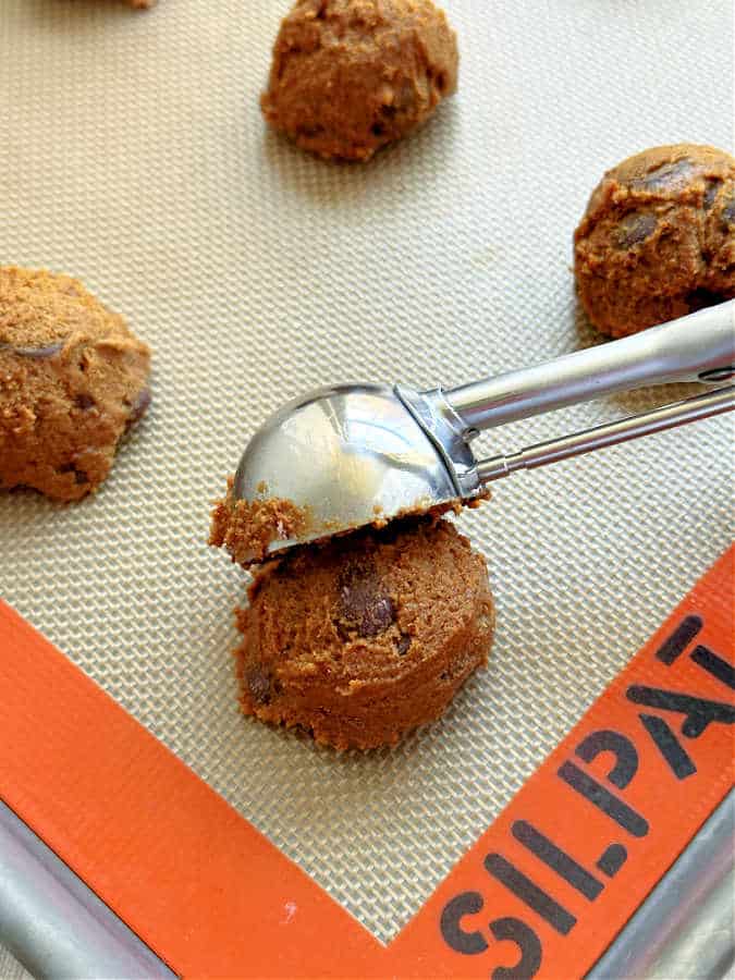 raw cookie dough balls of espresso cookies being placed on a baking sheet