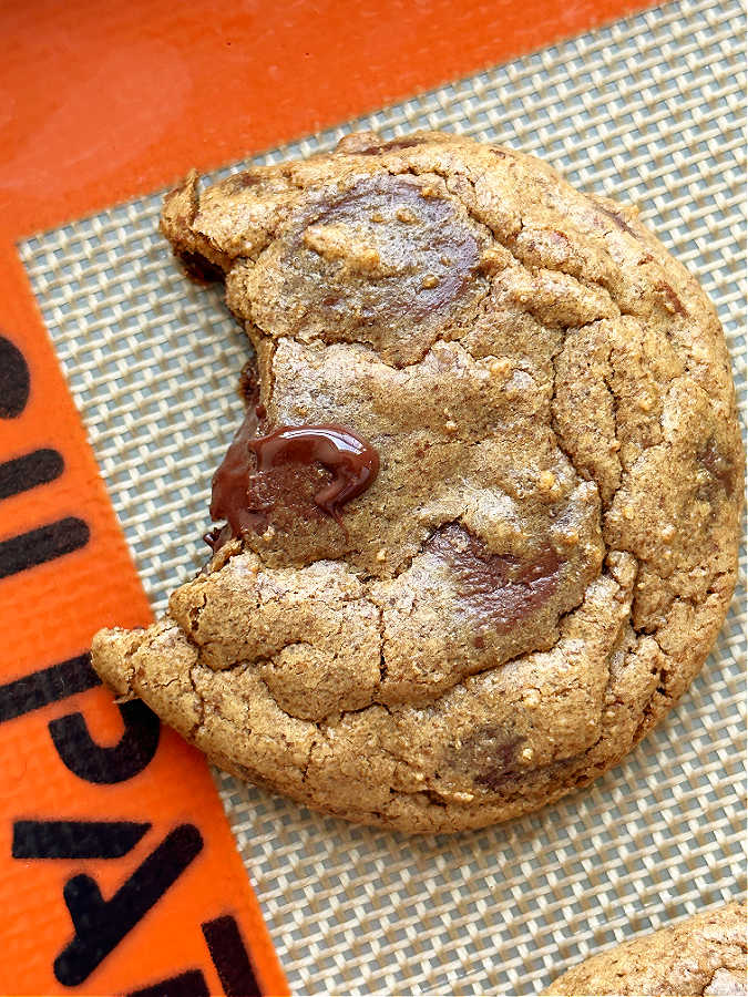 espresso cookie with a bite taken out of it on baking sheet