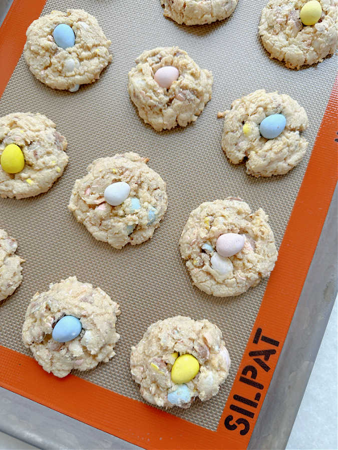 freshly baked mini egg cookies on a baking sheet lined with a silpat baking mat