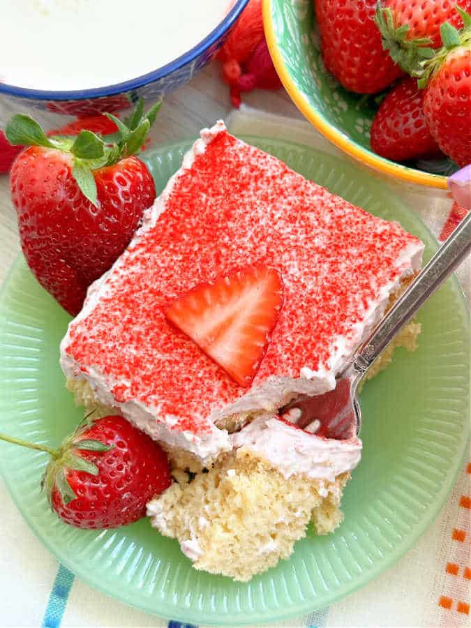 taking a bite of strawberry tres leches cake