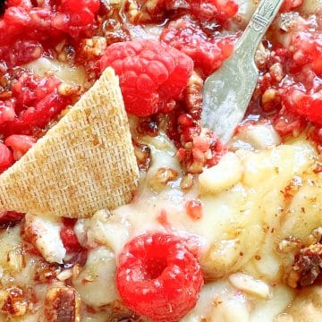 brie baked in the air fryer and topped with pecans, honey and fresh raspberries