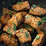 perfectly cooked and seasoned steak bites in the basket of the air fryer