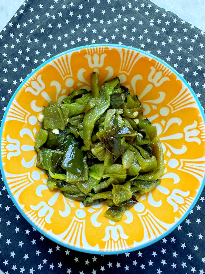 chopped roasted poblano pepper in a colorful yellow bowl