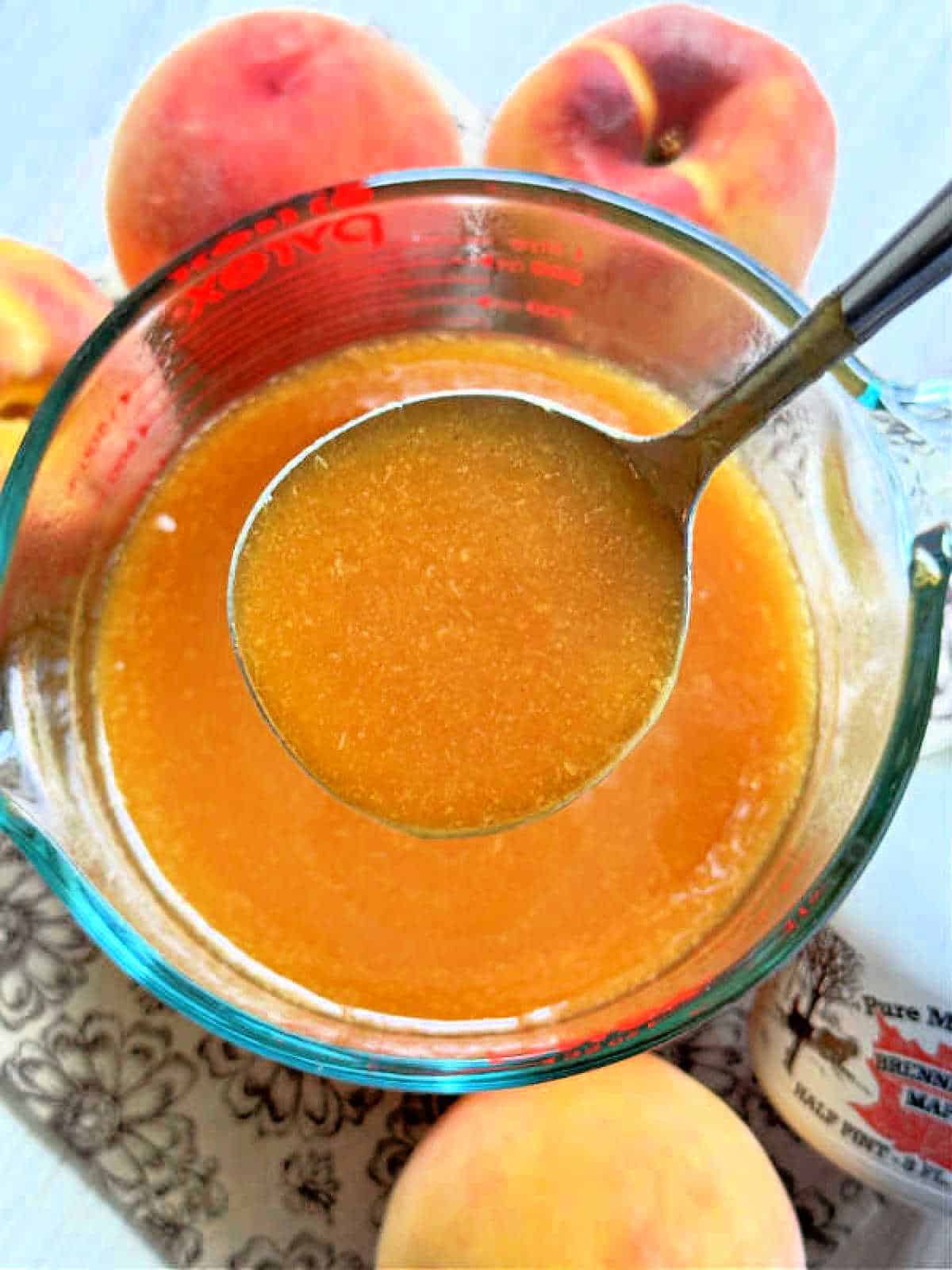 a ladle of fresh peach syrup ready to pour over pancakes